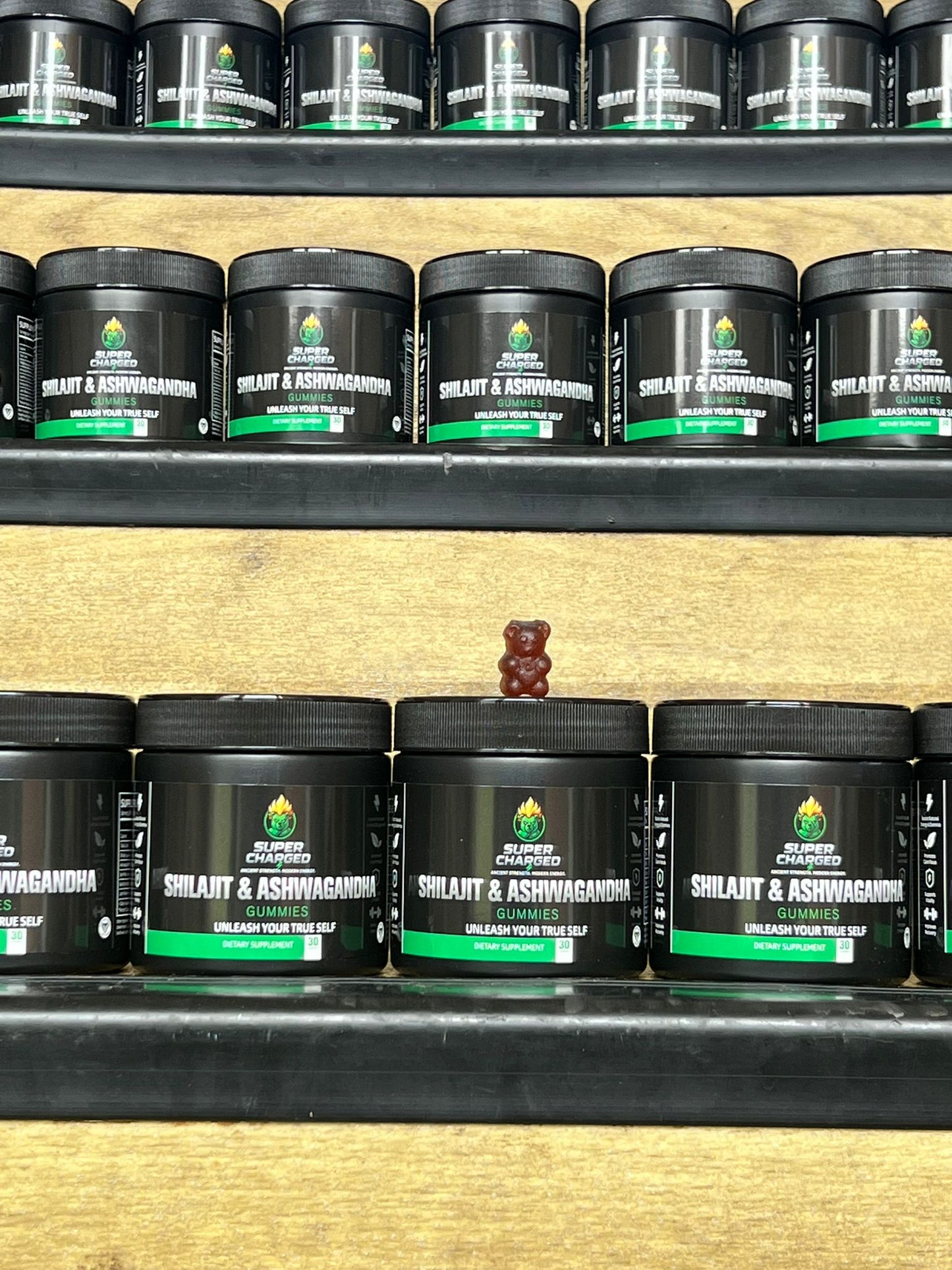 Shelf with black containers labeled 'Shilajit & Ashwagandha' on a wooden shelf.